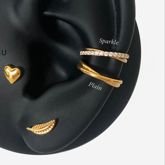 Black ear model with gold jewelry pieces on a white background, featuring the brand 'HYANGMI GU'.